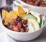Chilli with rice, avocado and tortilla chips in bowl