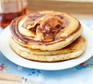 Fluffy pancakes on plate with maple syrup and pancetta