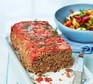 A serving plate with healthy Turkish meatloaf and a salad served alongside
