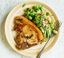 Pork chops with broad bean & minted Jersey smash served on a plate