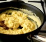 Close up of scrambled eggs being cooked in the pan