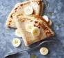 Gluten-free pancakes topped with banana and syrup