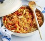 Chicken & chorizo jambalaya in a shallow cast iron dish with wooden spoon
