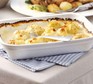Cauliflower cheese in large dish with spoon