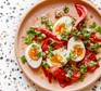 Roast peppers with ‘jammy’ eggs & almond & parsley dressing served on a plate