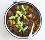 Spicy meatballs in a white pan with chilli black beans and avocado